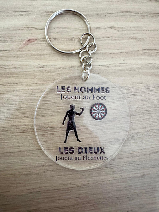 Porte-clés fléchettes humour – “Les hommes jouent au foot, les dieux jouent aux fléchettes”